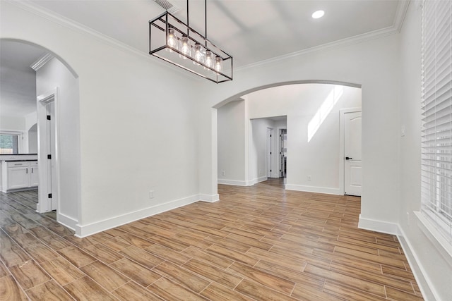 interior space featuring light hardwood / wood-style floors, crown molding, and an inviting chandelier