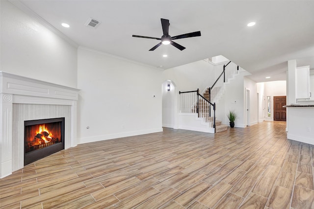 unfurnished living room featuring light wood-type flooring, ceiling fan, and crown molding