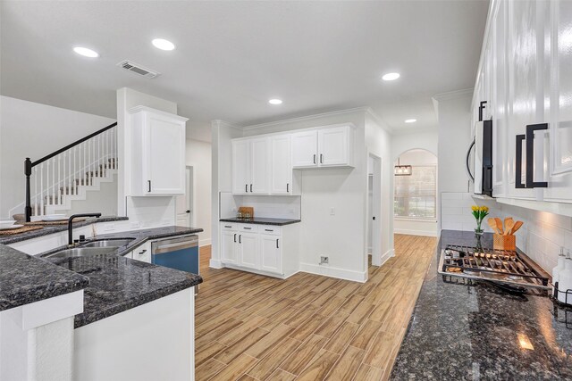 kitchen featuring crown molding, light wood-type flooring, white cabinetry, and stainless steel appliances