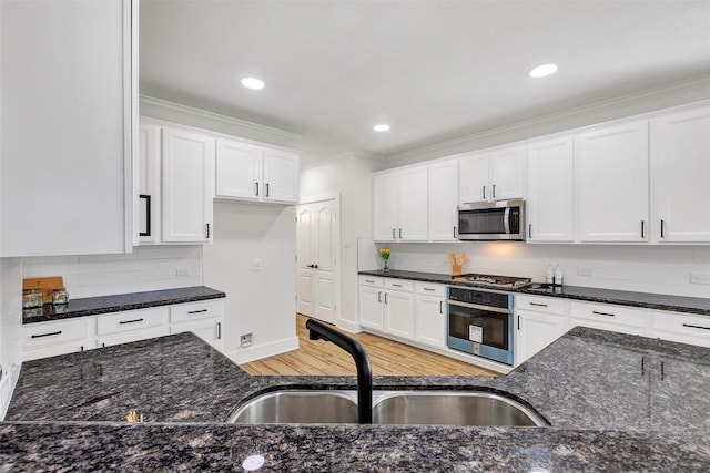 kitchen with white cabinetry, sink, light hardwood / wood-style floors, and appliances with stainless steel finishes