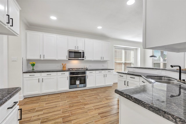 kitchen with white cabinets, light hardwood / wood-style floors, sink, and appliances with stainless steel finishes