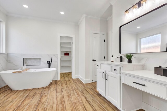 bathroom with vanity, wood-type flooring, crown molding, and a washtub