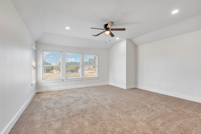 spare room with ceiling fan, light colored carpet, and lofted ceiling