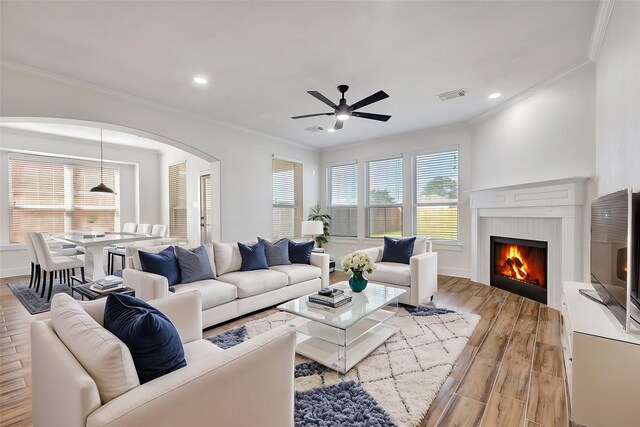 living room with ceiling fan, light hardwood / wood-style floors, and crown molding