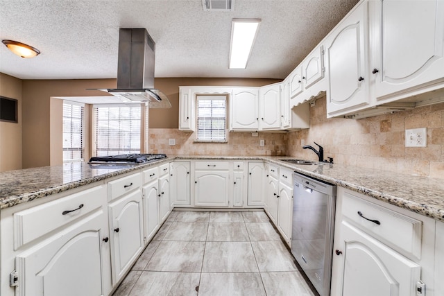 kitchen featuring appliances with stainless steel finishes, island range hood, white cabinetry, sink, and light stone countertops