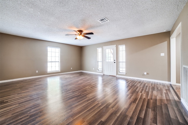 spare room featuring dark hardwood / wood-style flooring, ceiling fan, and a textured ceiling