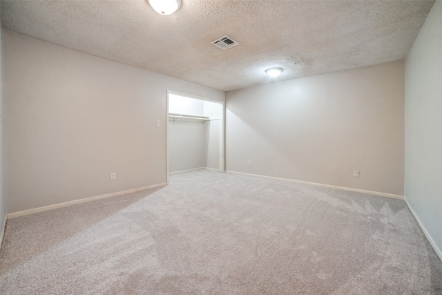 carpeted spare room featuring a textured ceiling