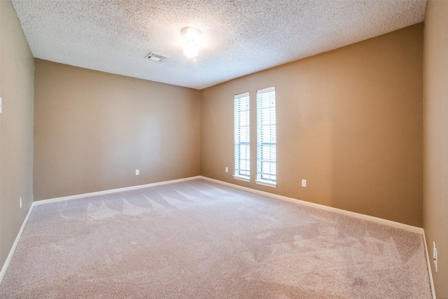 empty room featuring carpet and a textured ceiling