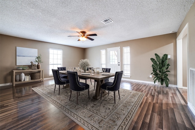 dining space featuring ceiling fan, dark wood-type flooring, a wealth of natural light, and a textured ceiling