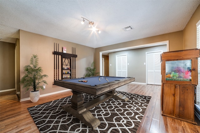 game room featuring pool table, a textured ceiling, and light hardwood / wood-style flooring