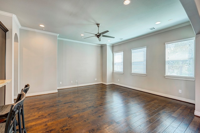 empty room with dark hardwood / wood-style flooring, plenty of natural light, and ornamental molding