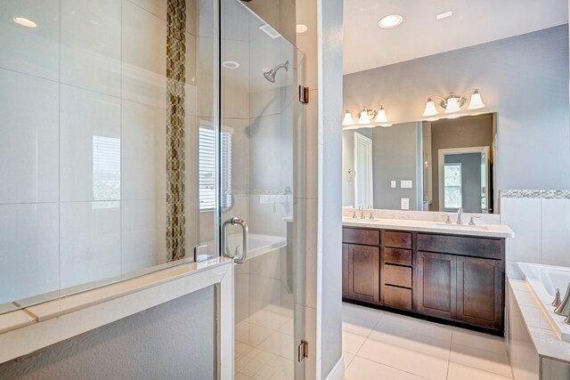 bathroom with tile patterned flooring, vanity, a healthy amount of sunlight, and plus walk in shower