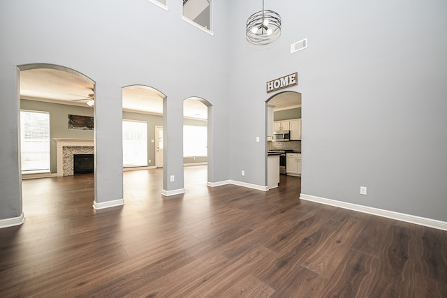 unfurnished living room with a fireplace, dark hardwood / wood-style flooring, and ceiling fan