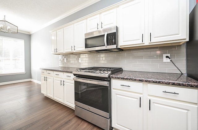 kitchen with stainless steel appliances, white cabinetry, crown molding, and dark hardwood / wood-style flooring