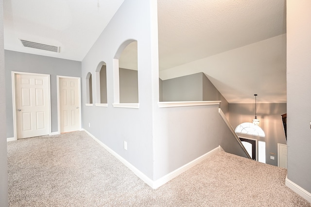 hall featuring lofted ceiling and carpet flooring