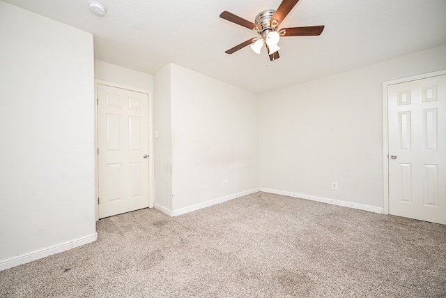 carpeted spare room with ceiling fan