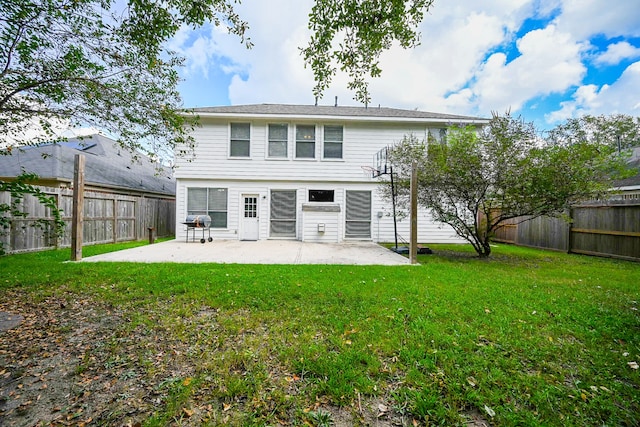 back of house featuring a lawn and a patio area