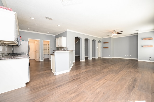 kitchen featuring white cabinetry, backsplash, crown molding, ceiling fan, and hardwood / wood-style flooring