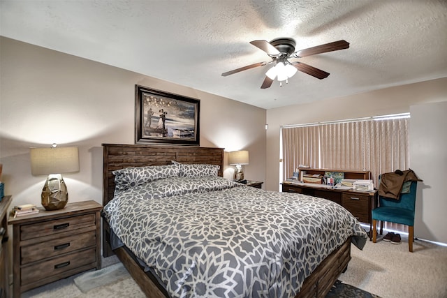 bedroom featuring ceiling fan, a textured ceiling, and light carpet