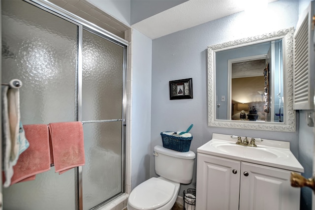 bathroom featuring vanity, toilet, and an enclosed shower