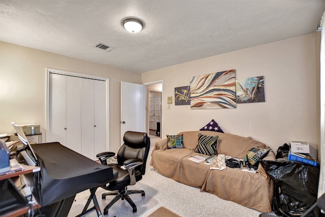 carpeted home office with a textured ceiling