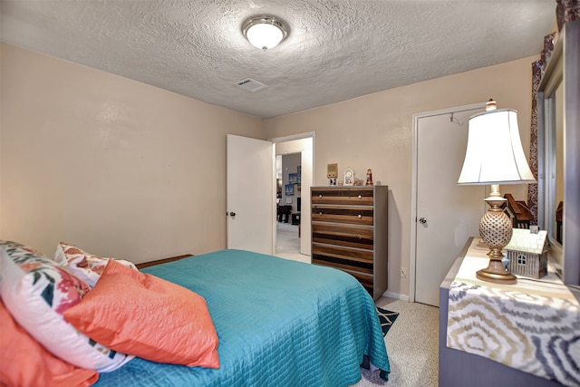 bedroom with light carpet and a textured ceiling