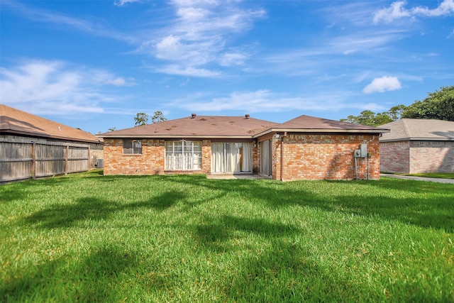 back of house with a lawn