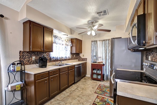 kitchen with stainless steel appliances, a textured ceiling, ceiling fan, dark brown cabinetry, and sink