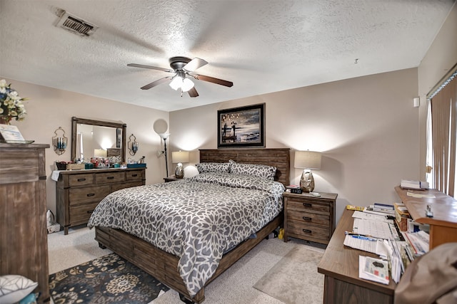 carpeted bedroom featuring ceiling fan and a textured ceiling