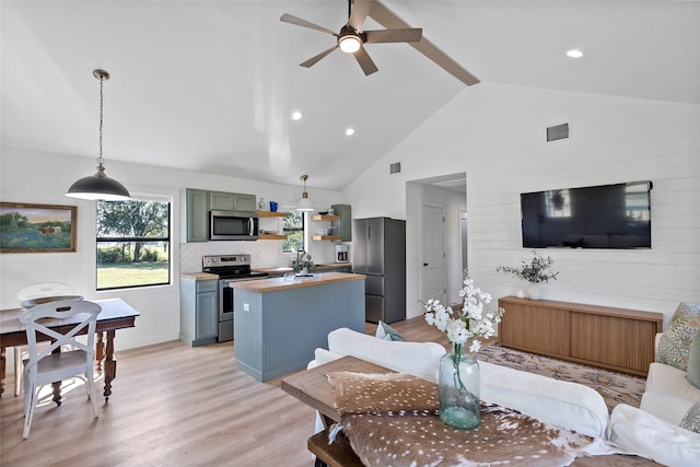 living room featuring ceiling fan, light hardwood / wood-style flooring, and high vaulted ceiling