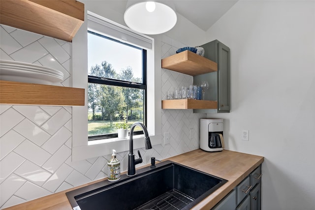 kitchen featuring hardwood / wood-style flooring, tasteful backsplash, sink, butcher block counters, and gray cabinetry