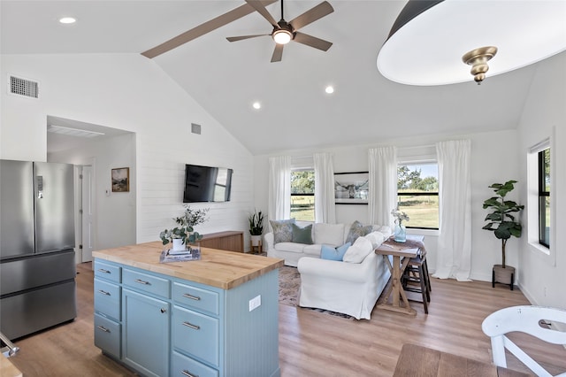 kitchen with stainless steel fridge, high vaulted ceiling, butcher block countertops, light wood-type flooring, and ceiling fan