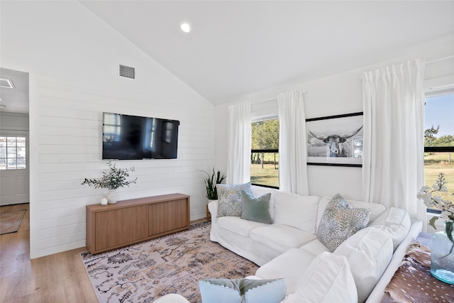 living room featuring light hardwood / wood-style flooring and high vaulted ceiling