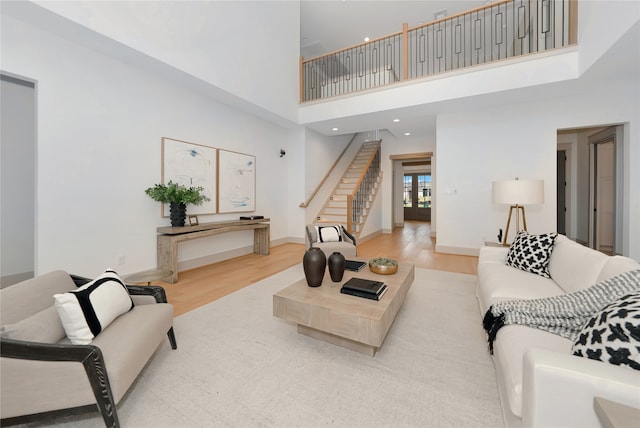 living room featuring a high ceiling and light hardwood / wood-style flooring