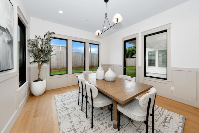 dining space with light wood-type flooring and a chandelier