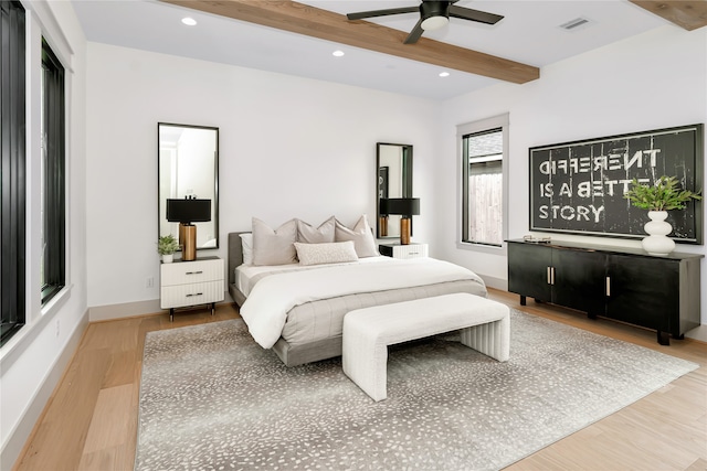 bedroom with ceiling fan, beamed ceiling, and light wood-type flooring