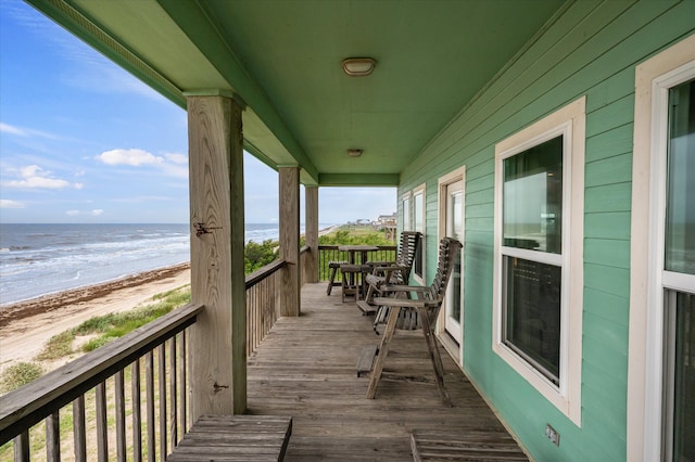 deck featuring a view of the beach and a water view