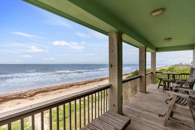 wooden deck with a water view and a view of the beach