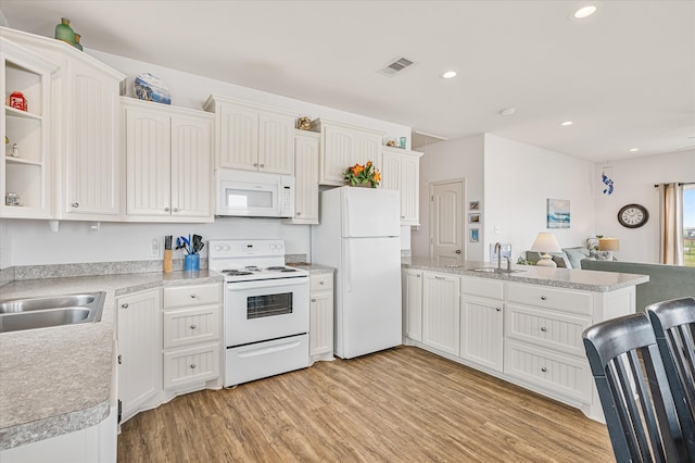 kitchen featuring light wood-type flooring, sink, white appliances, and white cabinetry