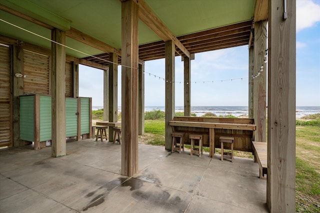 view of patio / terrace with a water view and an outbuilding