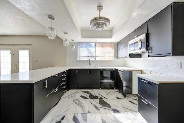 kitchen with kitchen peninsula, decorative light fixtures, tasteful backsplash, and sink