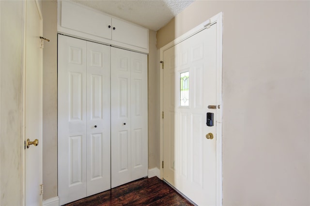 foyer with dark hardwood / wood-style flooring and a textured ceiling