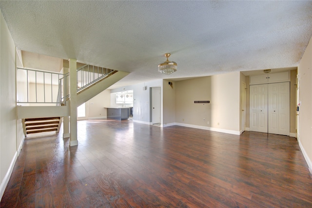 unfurnished living room with dark hardwood / wood-style flooring and a textured ceiling