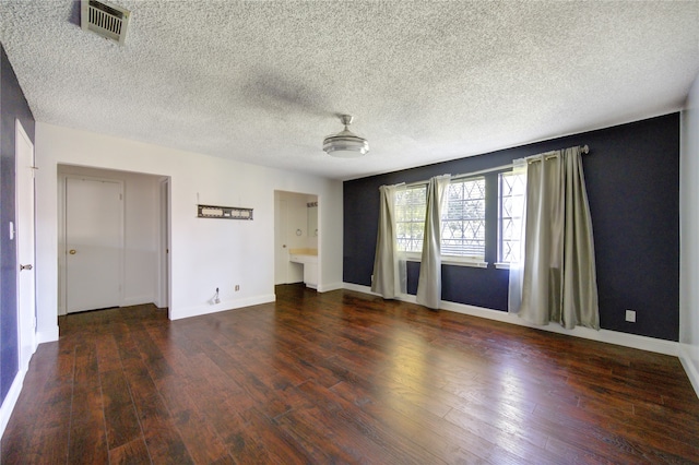 spare room featuring dark hardwood / wood-style floors and a textured ceiling