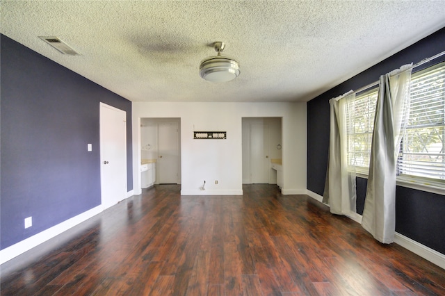 unfurnished room with a textured ceiling and dark wood-type flooring