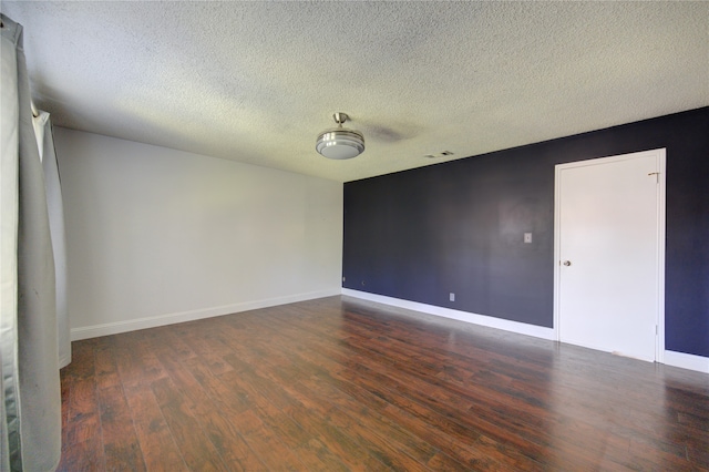 spare room with dark hardwood / wood-style flooring and a textured ceiling