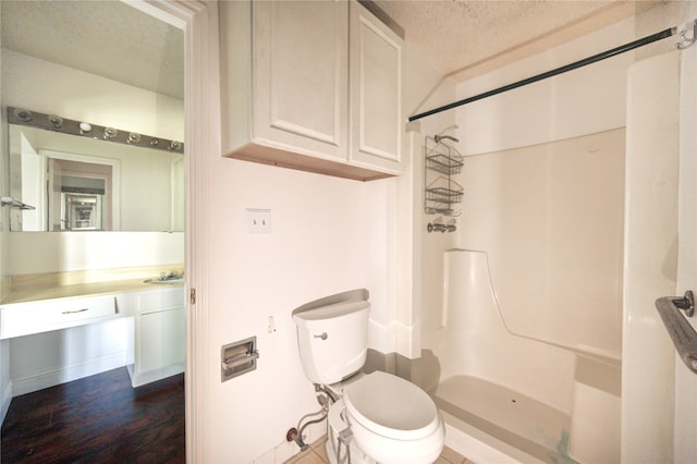 bathroom featuring a shower, sink, toilet, a textured ceiling, and wood-type flooring