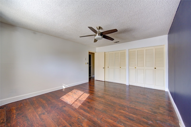 unfurnished bedroom featuring ceiling fan, dark hardwood / wood-style flooring, and a textured ceiling