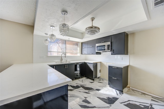 kitchen featuring sink, hanging light fixtures, black dishwasher, a raised ceiling, and a chandelier