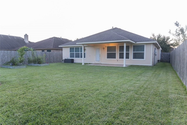 rear view of property featuring a trampoline, a lawn, and central air condition unit